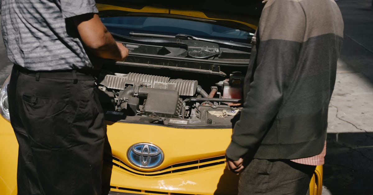 Car rental in France with U.S. drivers license - Men fixing problem in motor of car Car rental in France with U.S. drivers license - Men fixing problem in motor of car