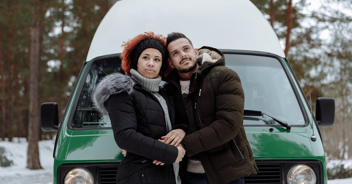 Car rental in Germany - are winter tyres included? - Man and Woman Being Affectionate While In Front of a Green Van Car rental in Germany - are winter tyres included? - Man and Woman Being Affectionate While In Front of a Green Van