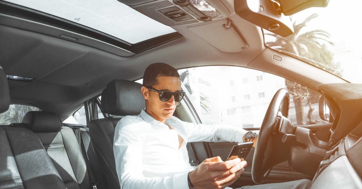 Car Seats in Saudi Arabia - Man in White Dress Shirt Holding Smartphone Car Seats in Saudi Arabia - Man in White Dress Shirt Holding Smartphone
