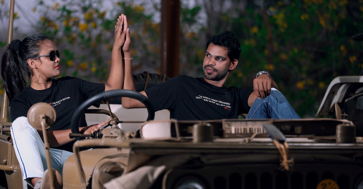 Carnet insurance for driving into Iran? - Man and Woman in Black Shirt Riding on a Vehicle Carnet insurance for driving into Iran? - Man and Woman in Black Shirt Riding on a Vehicle