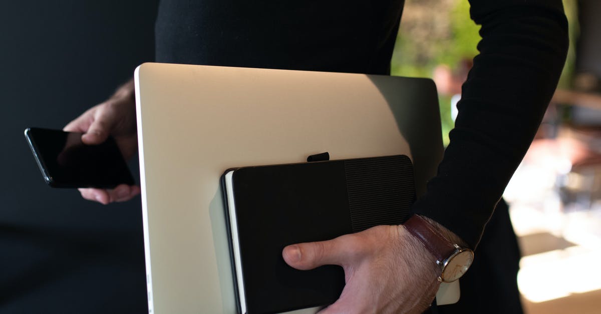 Carrying 3 laptops (1 new and 2 old) in hand luggage to India [duplicate] - A Person Carrying Laptop and Notebook