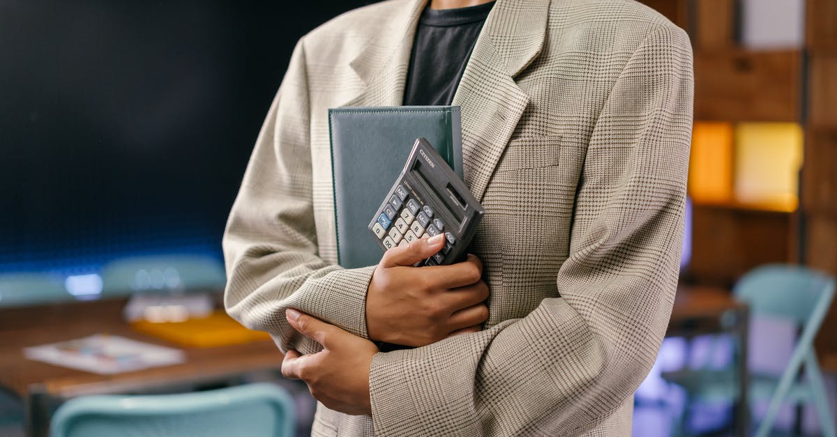 Carrying Bitcoin Internationally - Man in Gray Suit Jacket Holding Black Smartphone Carrying Bitcoin Internationally - Man in Gray Suit Jacket Holding Black Smartphone