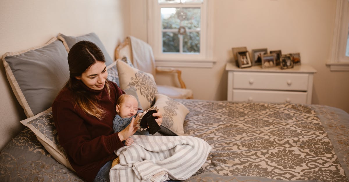 Carrying decent cutlery while flying - Mother Holding Her Baby while Looking at a Picture Frame Carrying decent cutlery while flying - Mother Holding Her Baby while Looking at a Picture Frame