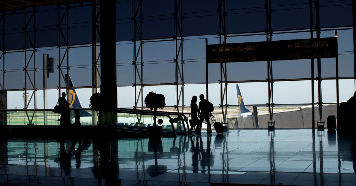 Carrying hard drives in checked in luggage - Silhouette of People Walking at the Airport Carrying hard drives in checked in luggage - Silhouette of People Walking at the Airport
