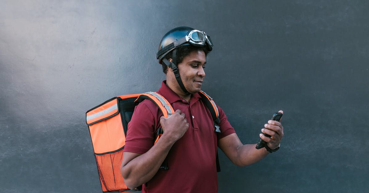 Cellphone service in Southeast Asia? - Man in Red Polo Shirt Wearing Helmet Holding Black and Gray Smartphone Cellphone service in Southeast Asia? - Man in Red Polo Shirt Wearing Helmet Holding Black and Gray Smartphone