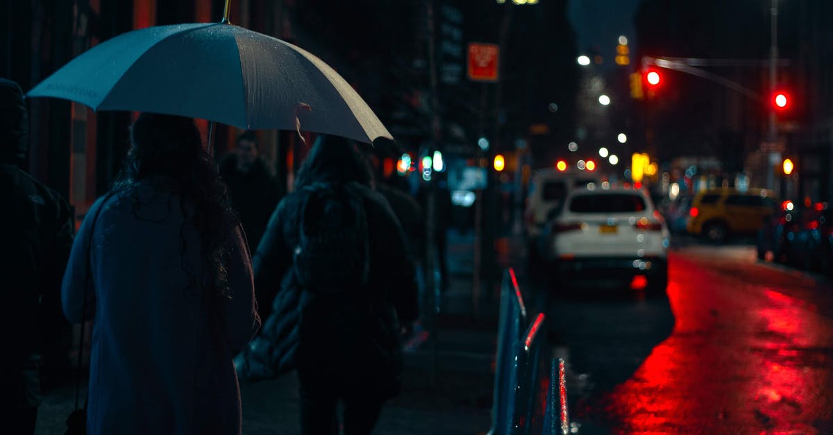Central America, rain season and electronics - Anonymous pedestrians walking along busy city street in autumn evening Central America, rain season and electronics - Anonymous pedestrians walking along busy city street in autumn evening