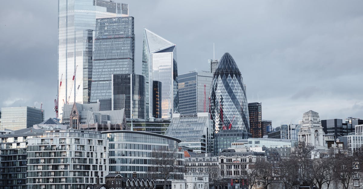 Central districts in London? - Modern multistory business centers with geometric architecture located on street against cloudy sky in downtown of London city in financial district Central districts in London? - Modern multistory business centers with geometric architecture located on street against cloudy sky in downtown of London city in financial district