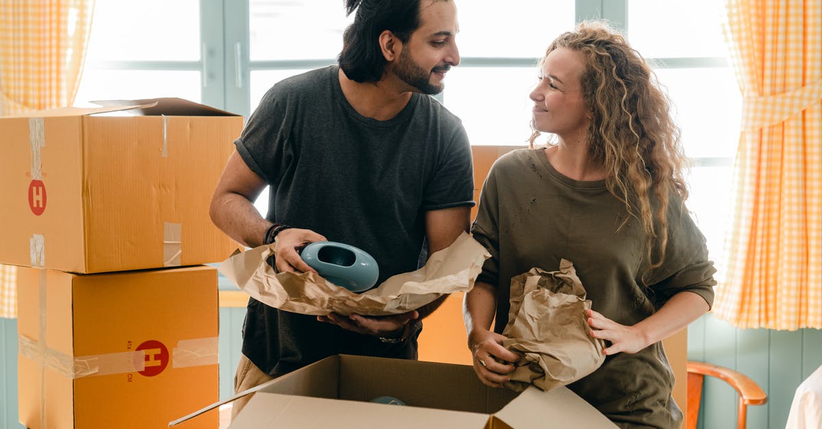 Ceramic knives and airport (or any other) security - Multiethnic couple packing ceramic belongings in parchment before relocation
