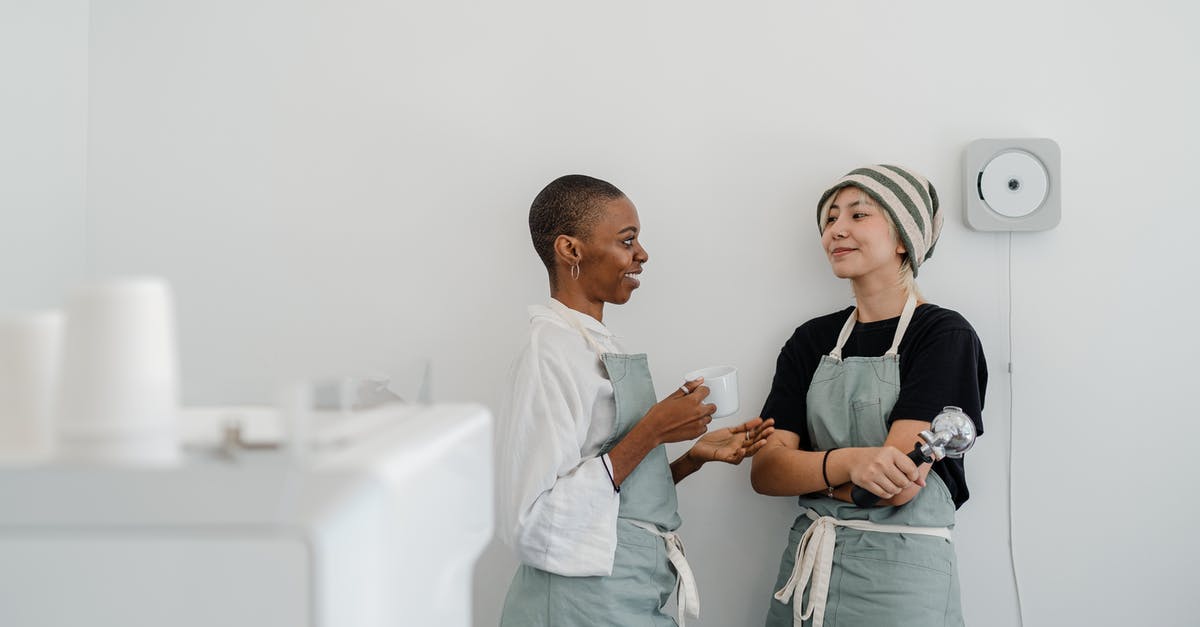Ceramic knives and airport (or any other) security - Couple of multiracial female baristas wearing apron standing near wall in modern coffee shop with minimal interior while drinking coffee and communicating and looking at each other