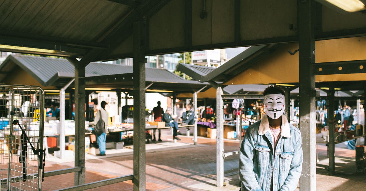 Changes to British transit visa policy - Unrecognizable black man in stylish clothes and Anonymous mask standing in local market in city and looking at camera in sunny day Changes to British transit visa policy - Unrecognizable black man in stylish clothes and Anonymous mask standing in local market in city and looking at camera in sunny day