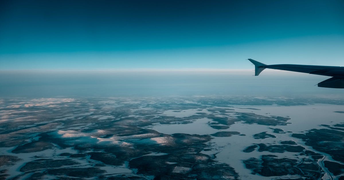 Changing dates for part of a flight - Airplane flying over wetland in evening Changing dates for part of a flight - Airplane flying over wetland in evening