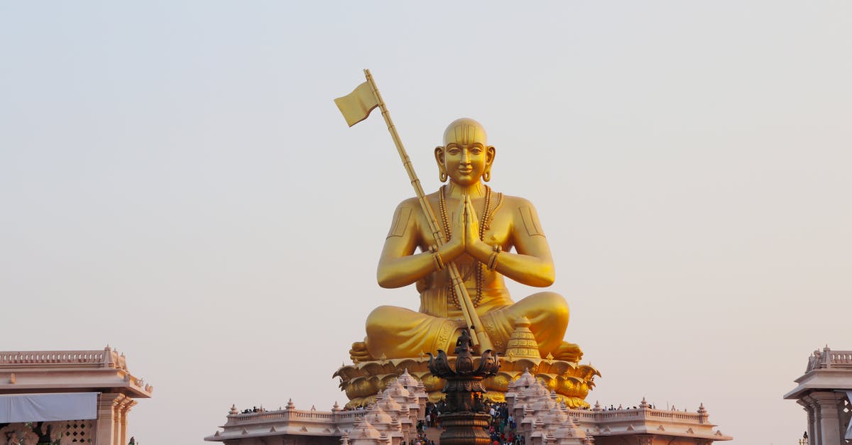 Charter flights to India - Gold Statue of Man Holding Flag Charter flights to India - Gold Statue of Man Holding Flag