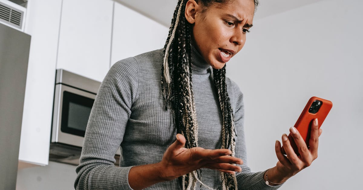 Cheap phone calls from Canada to Poland - Annoyed black woman having video chat on smartphone at home Cheap phone calls from Canada to Poland - Annoyed black woman having video chat on smartphone at home