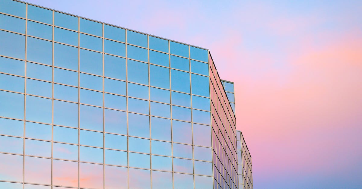 Cheap short-term accommodation in downtown Vancouver - Exterior of contemporary building with glass mirrored walls located in city against colorful sky at sunrise time Cheap short-term accommodation in downtown Vancouver - Exterior of contemporary building with glass mirrored walls located in city against colorful sky at sunrise time