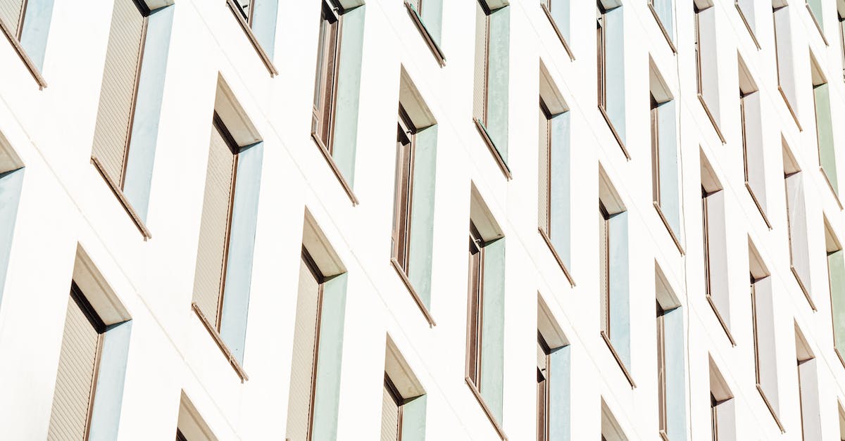Cheap short-term accommodation in downtown Vancouver - From below of lots of long narrow identical windows of contemporary construction in sunlight Cheap short-term accommodation in downtown Vancouver - From below of lots of long narrow identical windows of contemporary construction in sunlight