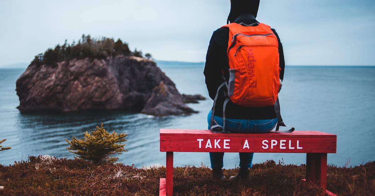 Cheapest trip from Canada to anywhere for visa purposes - Unrecognizable traveler admiring rocky ocean sitting on bench Cheapest trip from Canada to anywhere for visa purposes - Unrecognizable traveler admiring rocky ocean sitting on bench