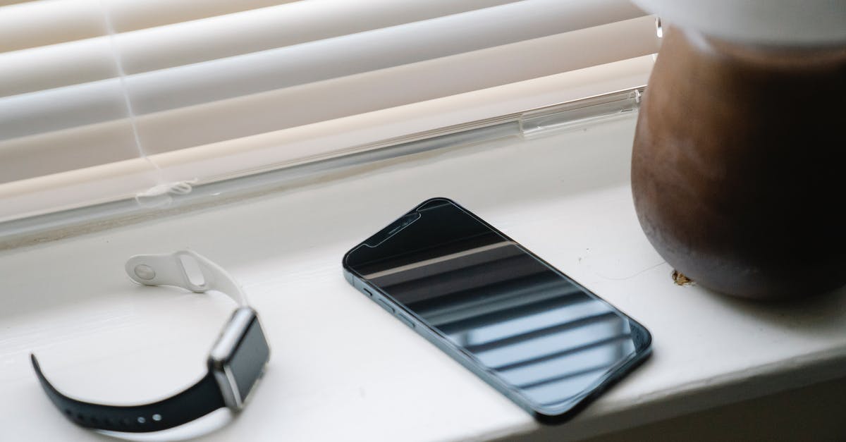 Check-in time for early morning flight from Minneapolis–St Paul - Smartphone and wristwatch on windowsill near lamp Check-in time for early morning flight from Minneapolis–St Paul - Smartphone and wristwatch on windowsill near lamp