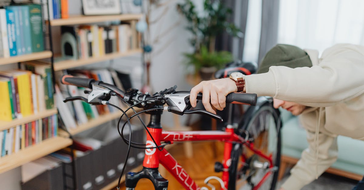 Checking a hire bike is properly docked - A Man Checking a Red Bicycle Checking a hire bike is properly docked - A Man Checking a Red Bicycle