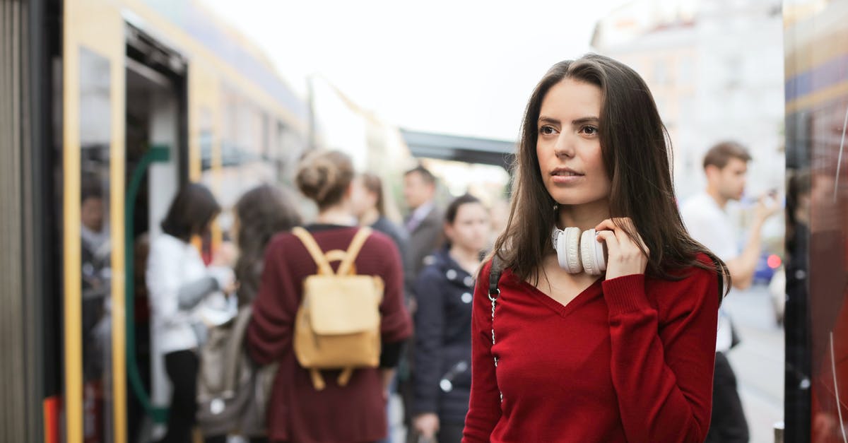 Checking luggage all the way through? - Young woman standing on train platform Checking luggage all the way through? - Young woman standing on train platform