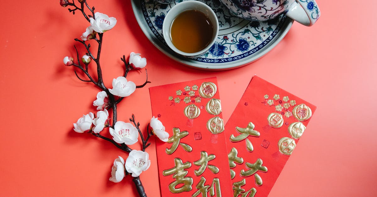 Chinese 5-year and 10-year visa eligibility for UK citizens - Top view of oriental packets with hieroglyphs against blossoming flower sprig and tea set during New Year holiday on red background Chinese 5-year and 10-year visa eligibility for UK citizens - Top view of oriental packets with hieroglyphs against blossoming flower sprig and tea set during New Year holiday on red background