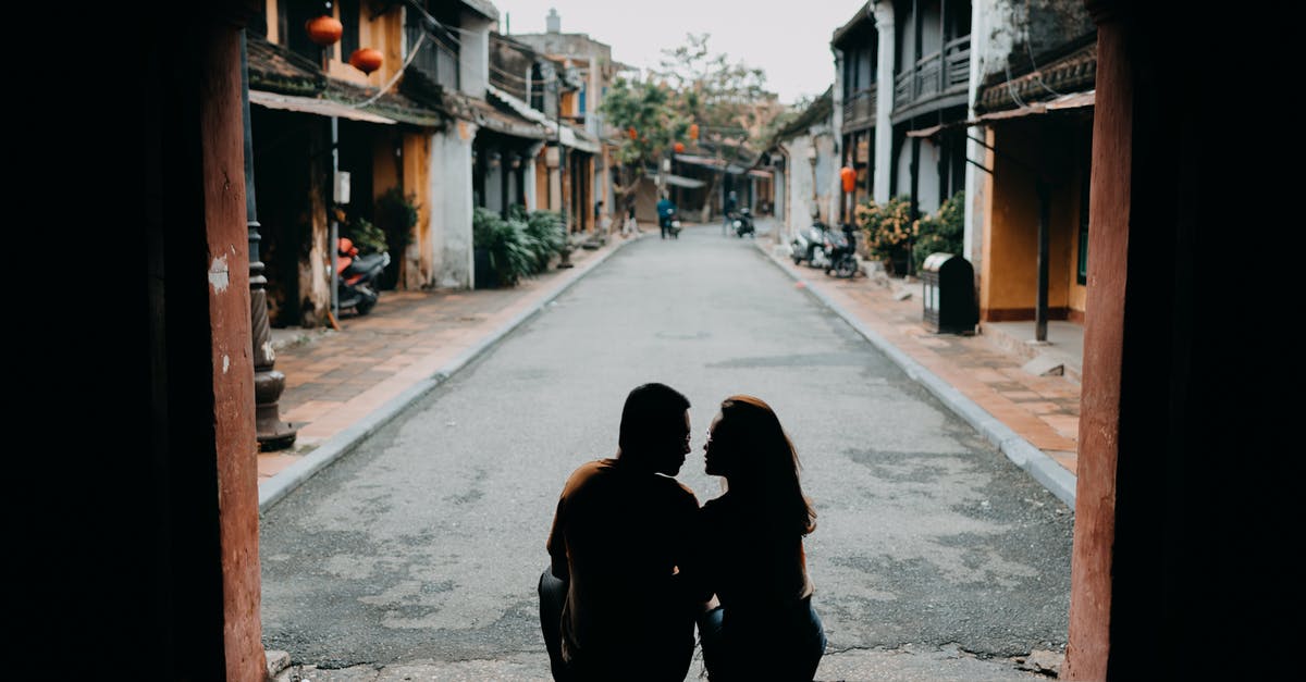 Chinese visa free with 2 passports - Back view of anonymous couple looking at each other on Chinese street in daytime Chinese visa free with 2 passports - Back view of anonymous couple looking at each other on Chinese street in daytime