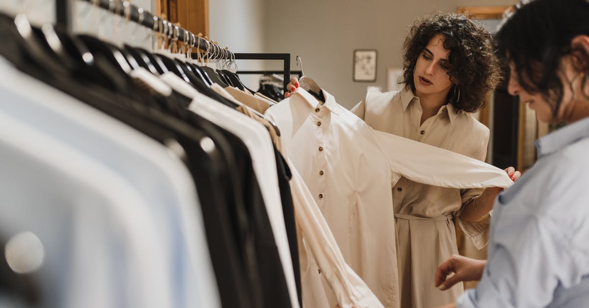 Choosing the Airline for a long-haul fligt, Europe to Taiwan - Women Looking at the Hanging White Long Sleeve Dress Choosing the Airline for a long-haul fligt, Europe to Taiwan - Women Looking at the Hanging White Long Sleeve Dress