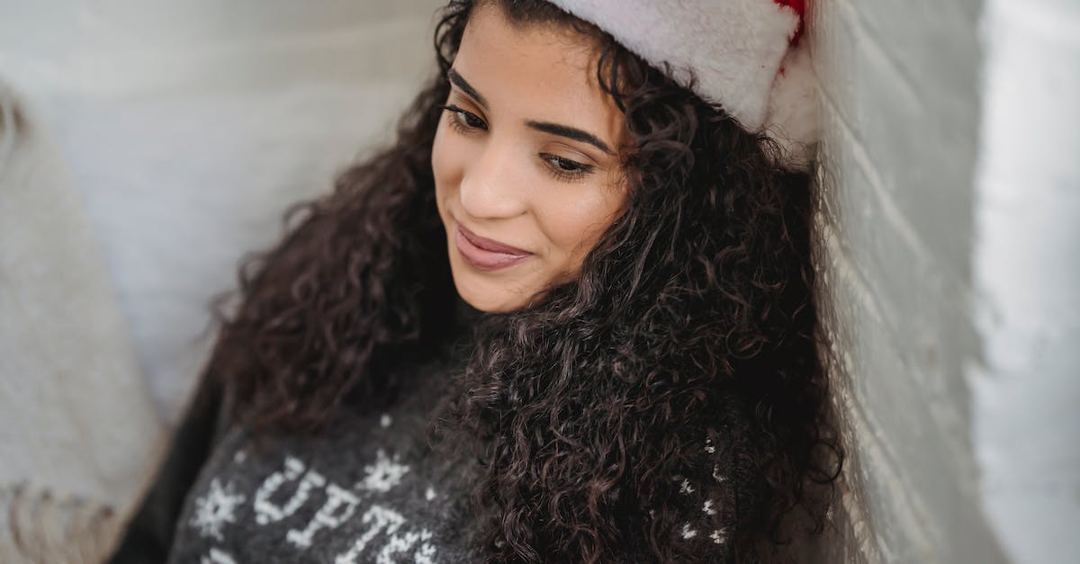 Christmas eve advice for a backpacker thinking of flying in to Germany - Young woman in Santa hat sitting on floor and looking away Christmas eve advice for a backpacker thinking of flying in to Germany - Young woman in Santa hat sitting on floor and looking away