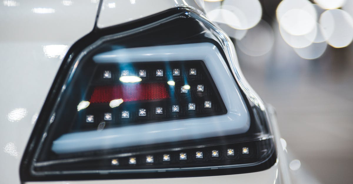 Circumnavigating North America in an Electric Car - where to buy? [closed] - Closeup of shiny white colored vehicle with stylish headlight against blurred lights of parking lot