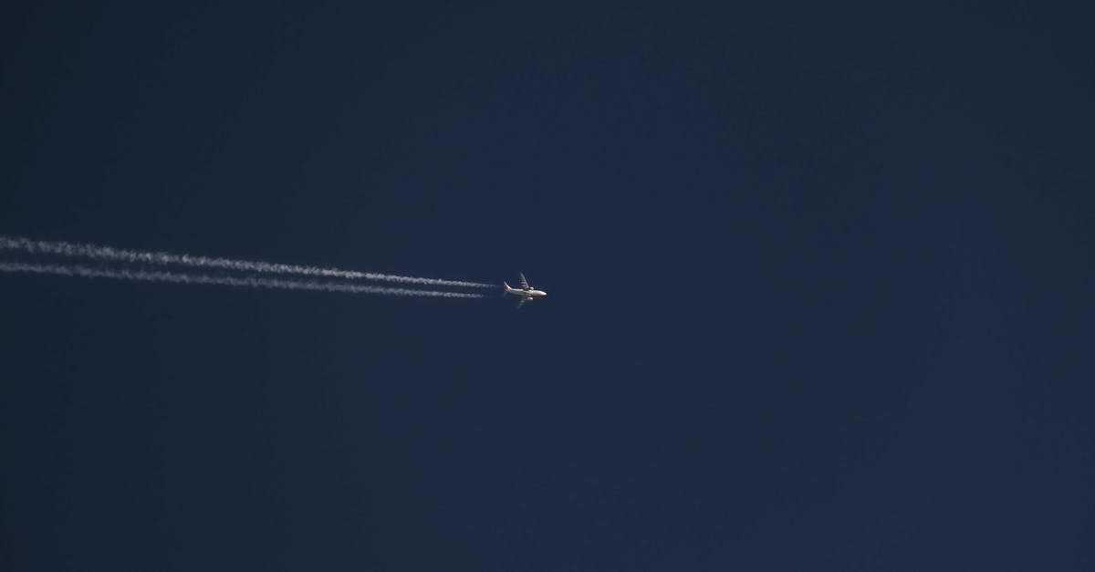Clearing TSA at JFK for international flight - From below of modern distant airplane flying high in air over clear cloudless blue sky with white trace on sunny day Clearing TSA at JFK for international flight - From below of modern distant airplane flying high in air over clear cloudless blue sky with white trace on sunny day
