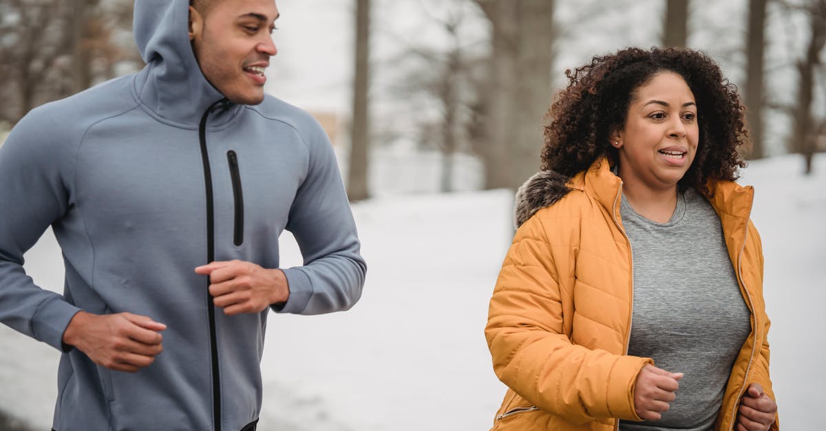Coach platform positions for trains in Austria - Positive African American male personal instructor running with overweight female in park in winter day Coach platform positions for trains in Austria - Positive African American male personal instructor running with overweight female in park in winter day