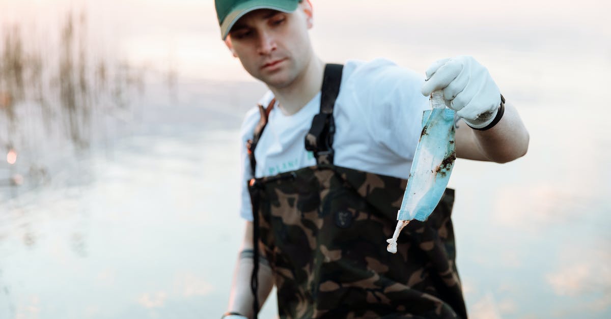 Collecting bags to go thru customs? [closed] - A Man Holding Used Face Masks From the River