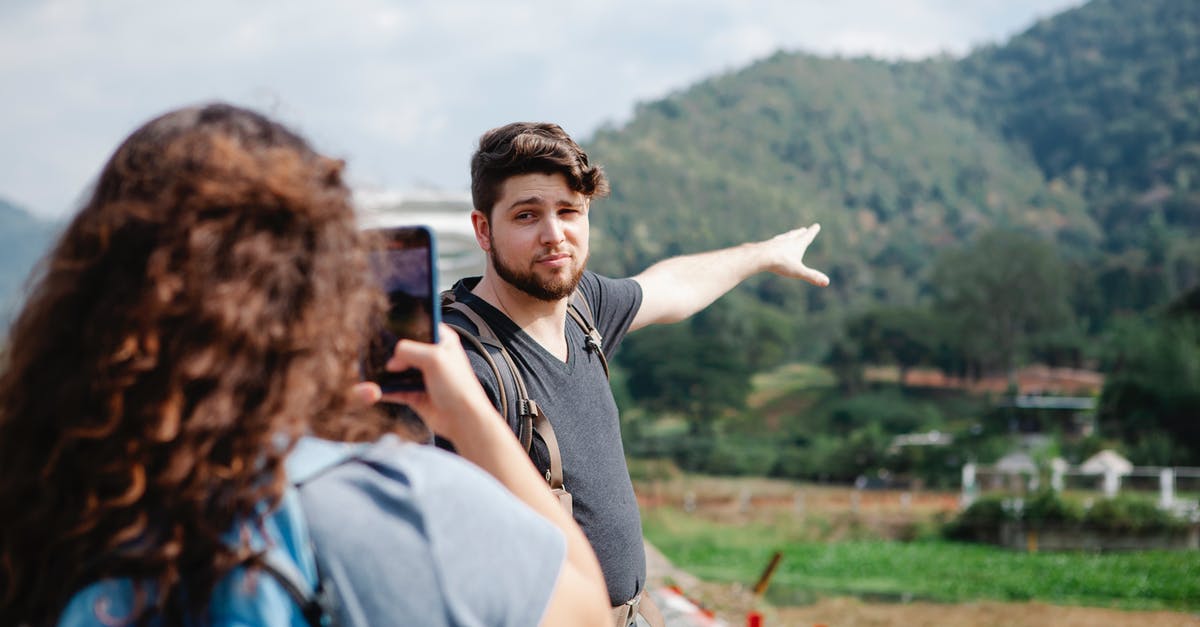 Combining Navigo Pass with an SNCF point to point ticket outside Île-de-France - Back view of unrecognizable woman in casual clothes taking photo on smartphone of pensive boyfriend pointing at green hills during hike in countryside in sunny day Combining Navigo Pass with an SNCF point to point ticket outside Île-de-France - Back view of unrecognizable woman in casual clothes taking photo on smartphone of pensive boyfriend pointing at green hills during hike in countryside in sunny day