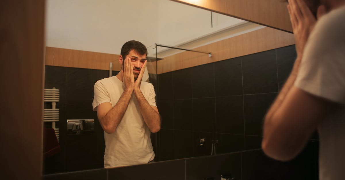 Compensation from hotel - Tired man looking in mirror in bathroom Compensation from hotel - Tired man looking in mirror in bathroom