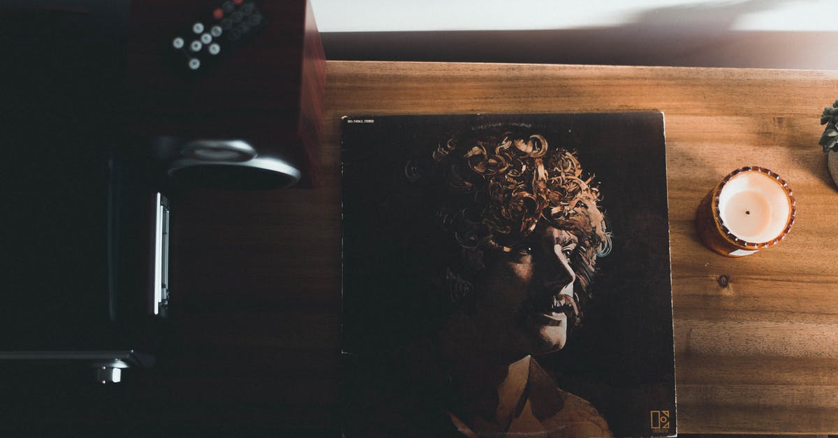 Complete record of travels - Top View Photography of Vinyl Album Case Near White Tealight Candle Placed on Brown Table