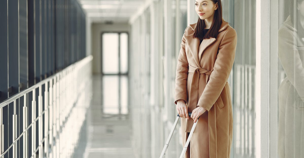 Conflicting answers about Transiting Zurich International Airport - Content woman with suitcase waiting for boarding in airport Conflicting answers about Transiting Zurich International Airport - Content woman with suitcase waiting for boarding in airport