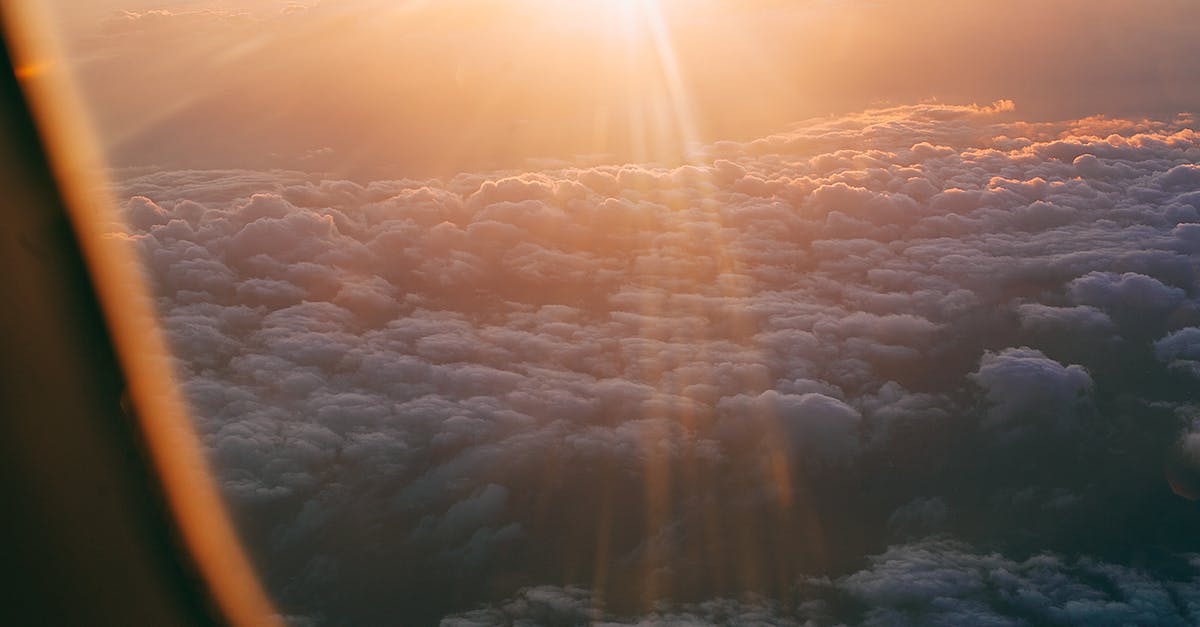 Connecting flight through Dubai with an Israeli/Jewish name - Through plane window of dark endless clouds under bright orange light of sun Connecting flight through Dubai with an Israeli/Jewish name - Through plane window of dark endless clouds under bright orange light of sun