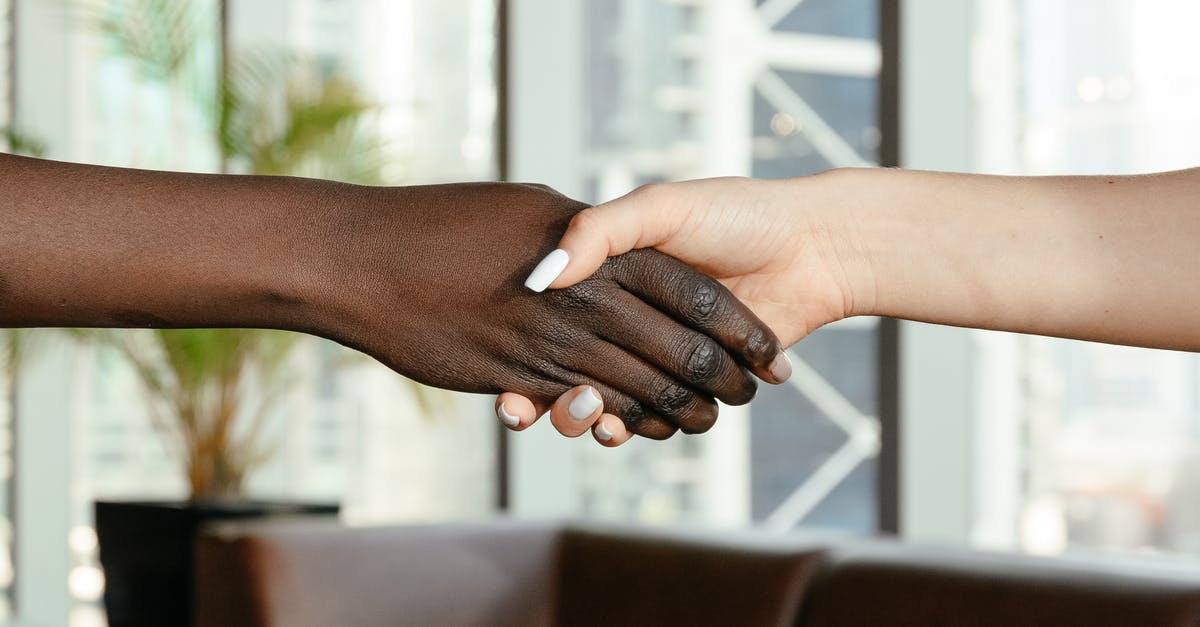 Connecting flights with partner airlines - Crop anonymous diverse women shaking hands together on blurred background of contemporary office Connecting flights with partner airlines - Crop anonymous diverse women shaking hands together on blurred background of contemporary office