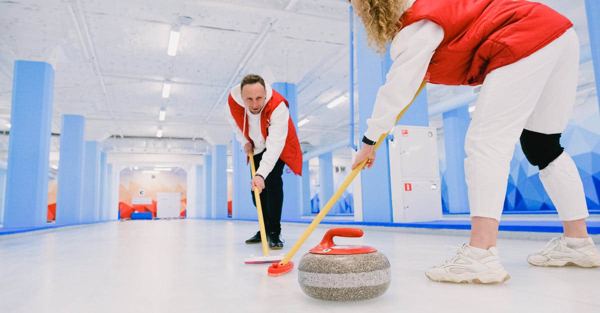 Connecting from ICE to regional trains (Deutsche Bahn) - Low angle of male and female players sweeping ice sheet with brooms in path of granite stone during curling training Connecting from ICE to regional trains (Deutsche Bahn) - Low angle of male and female players sweeping ice sheet with brooms in path of granite stone during curling training