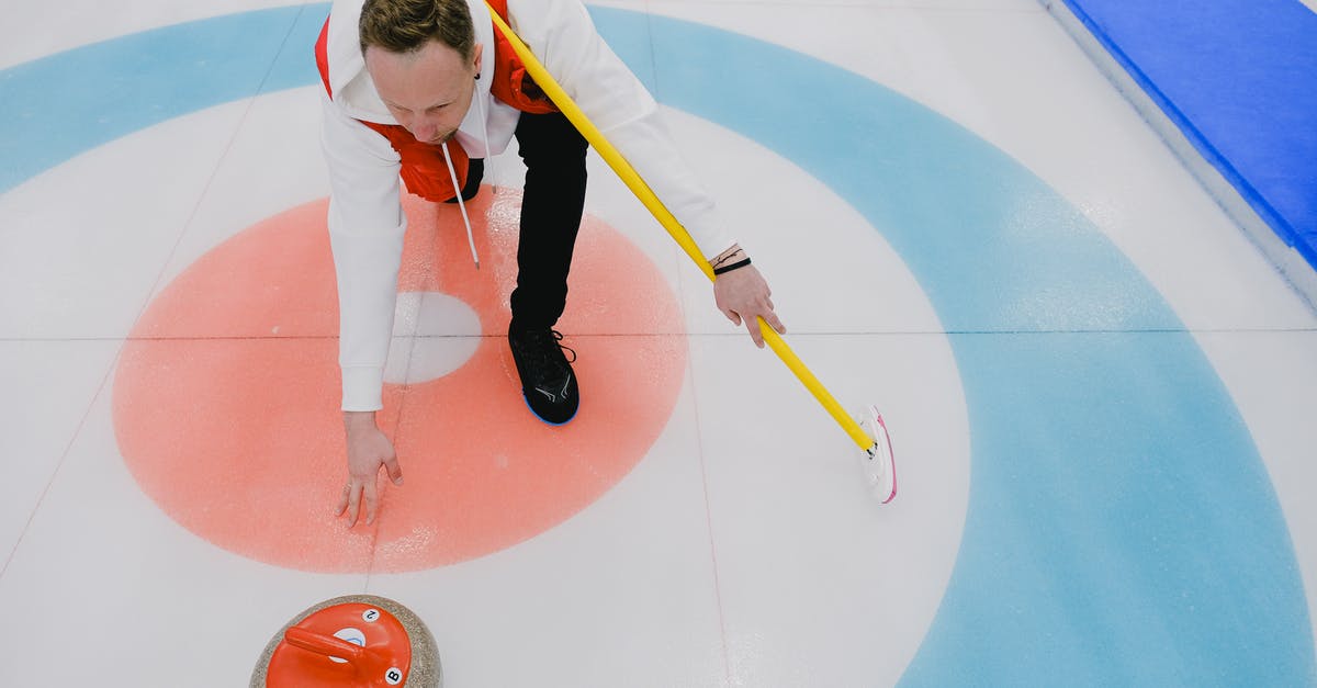 Connecting from ICE to regional trains (Deutsche Bahn) - From above of concentrated sportsman in activewear throwing stone during curling competition on ice rink in daytime Connecting from ICE to regional trains (Deutsche Bahn) - From above of concentrated sportsman in activewear throwing stone during curling competition on ice rink in daytime