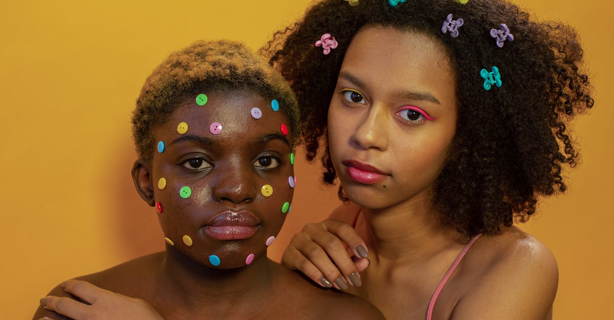 Connecting in Dubai on different airlines - Tender multiethnic friends with bright decorations looking at camera on yellow background of studio Connecting in Dubai on different airlines - Tender multiethnic friends with bright decorations looking at camera on yellow background of studio