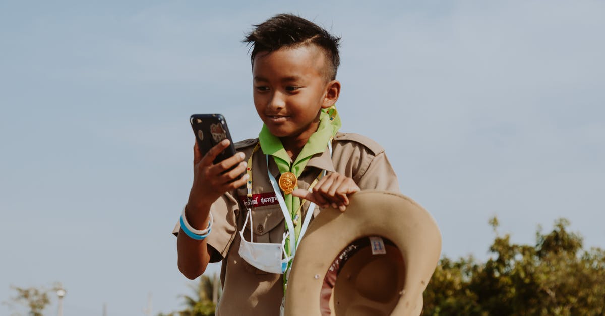 Connecting separate Airlines in Thailand - Boy Scout Looking at Smart Phone Connecting separate Airlines in Thailand - Boy Scout Looking at Smart Phone