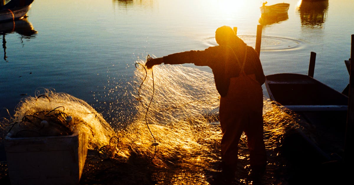Contact Fisherman Guesthouse in Penang - A Man Holding Fishing Net while Standing on Shore during Sunset Contact Fisherman Guesthouse in Penang - A Man Holding Fishing Net while Standing on Shore during Sunset