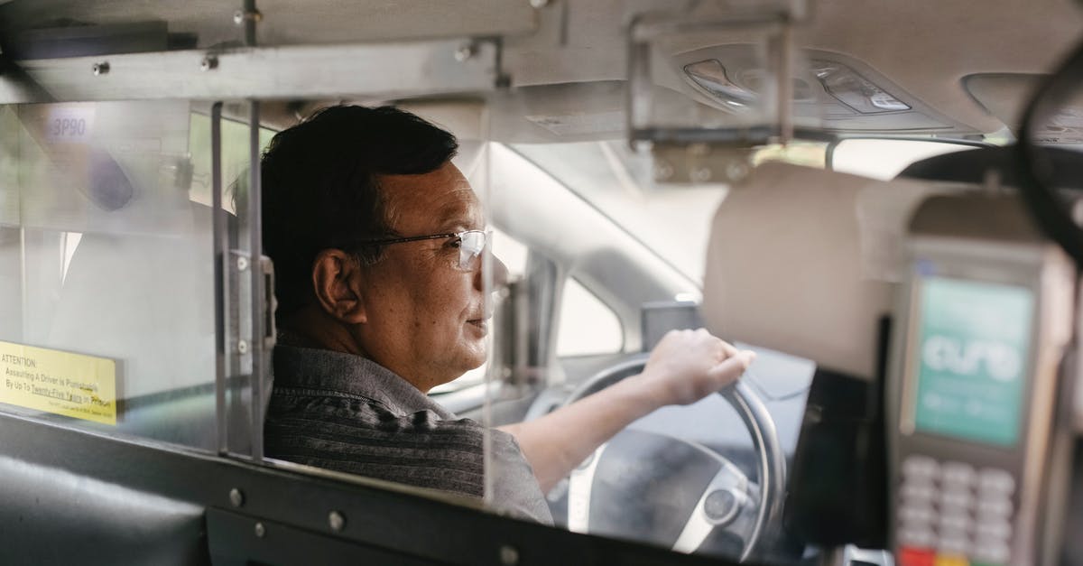 Contactless virtual Visa card payments in Yodobashi, Japan - Mature taxi driver in vehicle during trip Contactless virtual Visa card payments in Yodobashi, Japan - Mature taxi driver in vehicle during trip