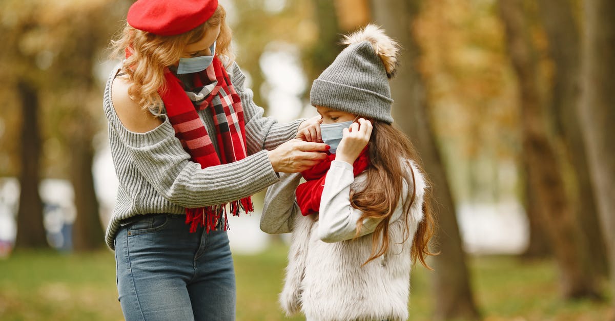 Coronavirus affected co-passenger; what to do? - Woman Putting Face Mask On A Girl Coronavirus affected co-passenger; what to do? - Woman Putting Face Mask On A Girl
