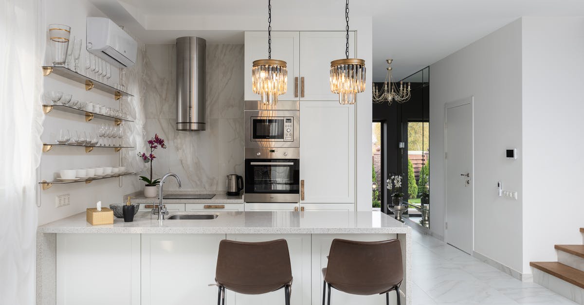 Corridor seats on the TGV — why? Are seat reservations not always mandatory? - Interior of contemporary kitchen with modern appliances and chairs at white counter near  wall with shelves in spacious apartment near stairs