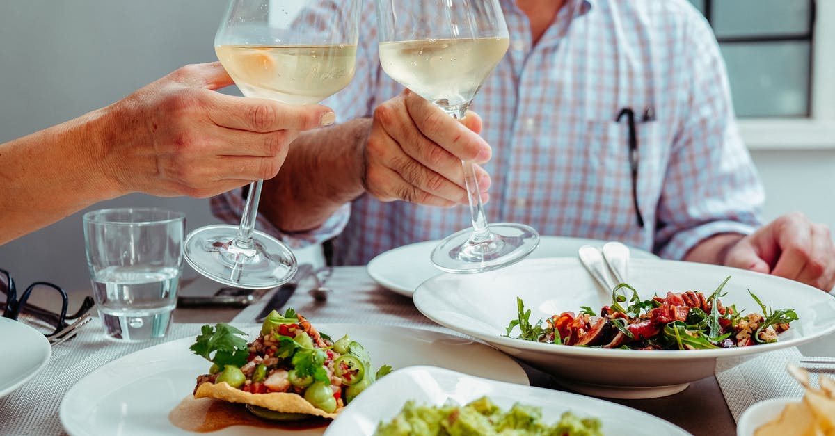 Could a person stay in the Schengen area for two consecutive 90 day periods with two different passports? [closed] - Two Unrecognizable People Holding Glasses of White Wine at Vegan Lunch
