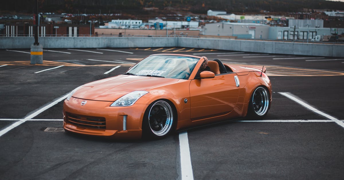 Creative ways to get from NY City to New Haven CT not using cars/vans [closed] - From above side view of modern style automobile with convertible top on asphalt pavement with marking lines in city parking lot behind cement fence and mountain with trees