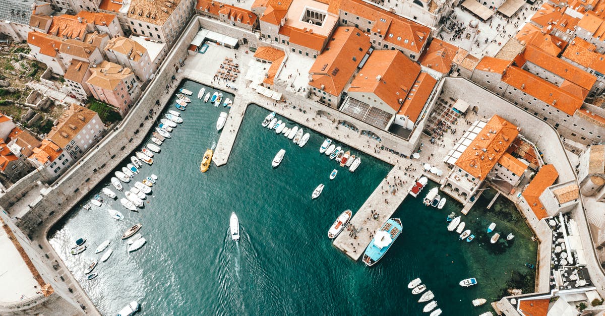 Croatia & Bosnia-Herzegovina Border between Split - Dubrovnik - Breathtaking drone view of coastal town with traditional red roofed buildings and harbor with moored boats in Croatia Croatia & Bosnia-Herzegovina Border between Split - Dubrovnik - Breathtaking drone view of coastal town with traditional red roofed buildings and harbor with moored boats in Croatia