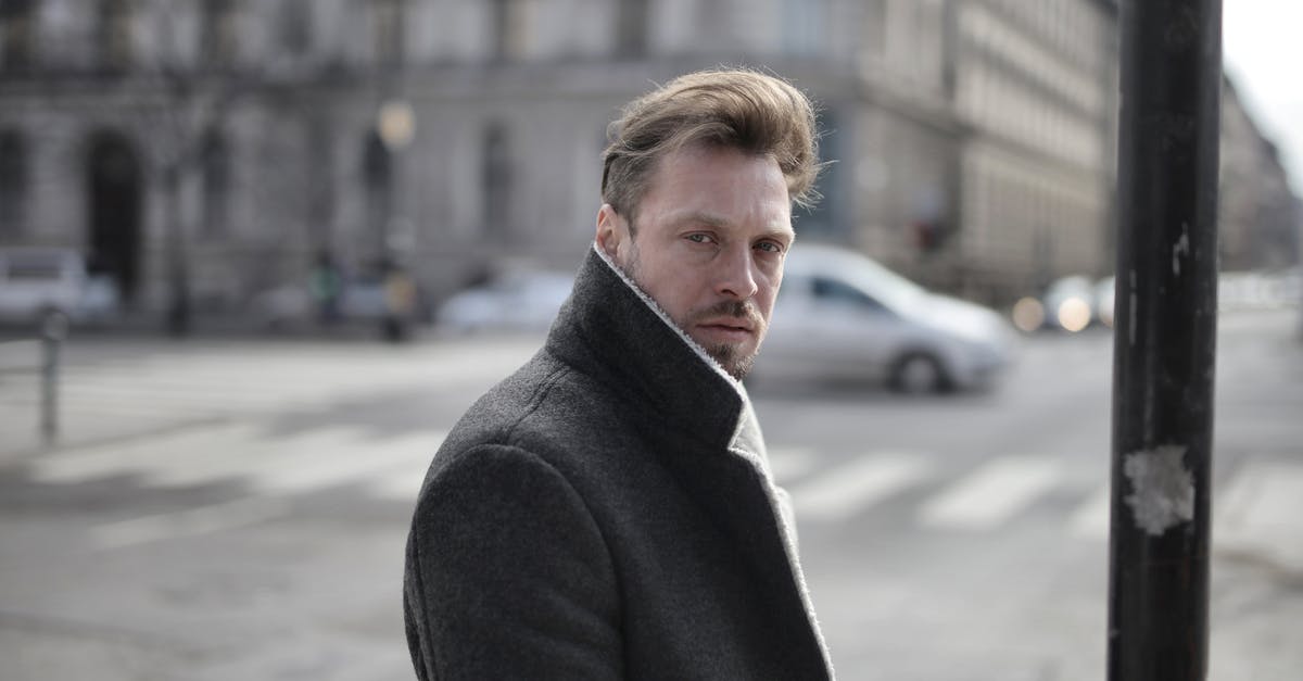 Cross Border Work Visa Requirement? - Side view of handsome male wearing classy jacket crossing road on sunny day and looking at camera Cross Border Work Visa Requirement? - Side view of handsome male wearing classy jacket crossing road on sunny day and looking at camera