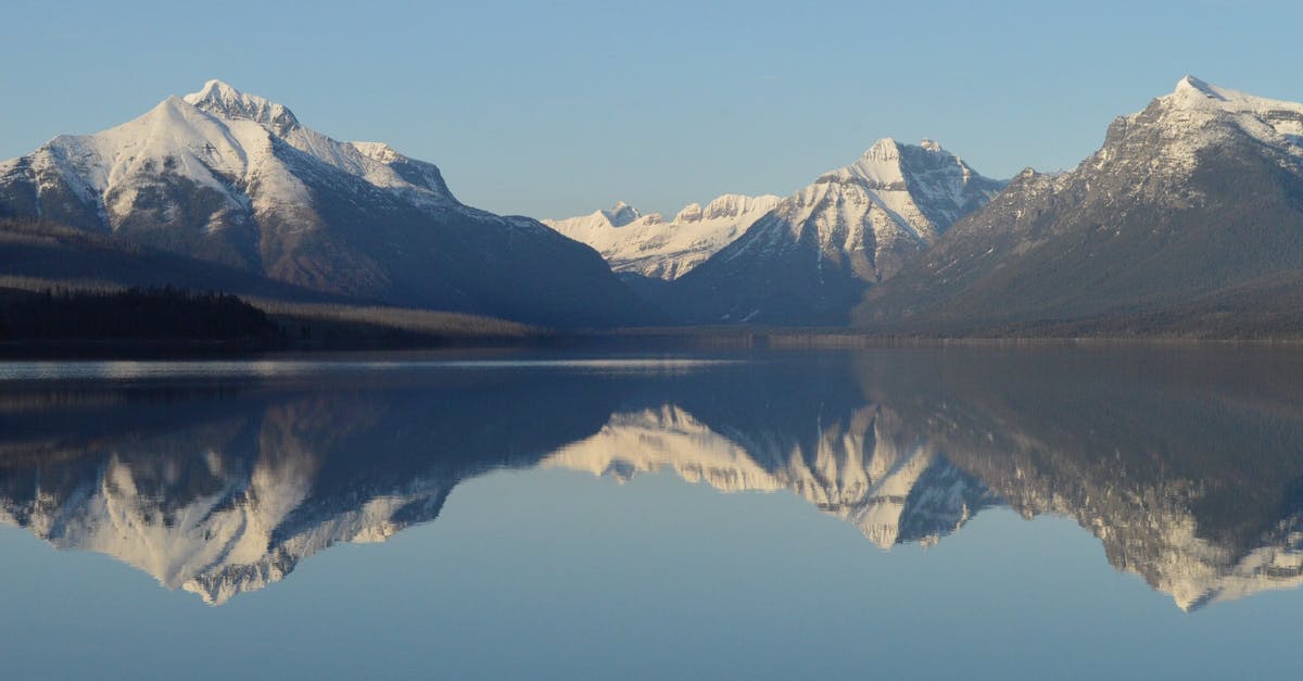 Cross US-Canada border at Glacier NP - Scenic View of Lake and Mountains Against Sky Cross US-Canada border at Glacier NP - Scenic View of Lake and Mountains Against Sky